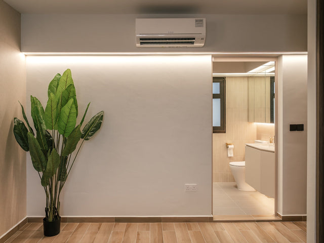 Cove strip lighting glowing along the top of a wall in an Eunos BTO, with a lit bathroom visible through the doorway